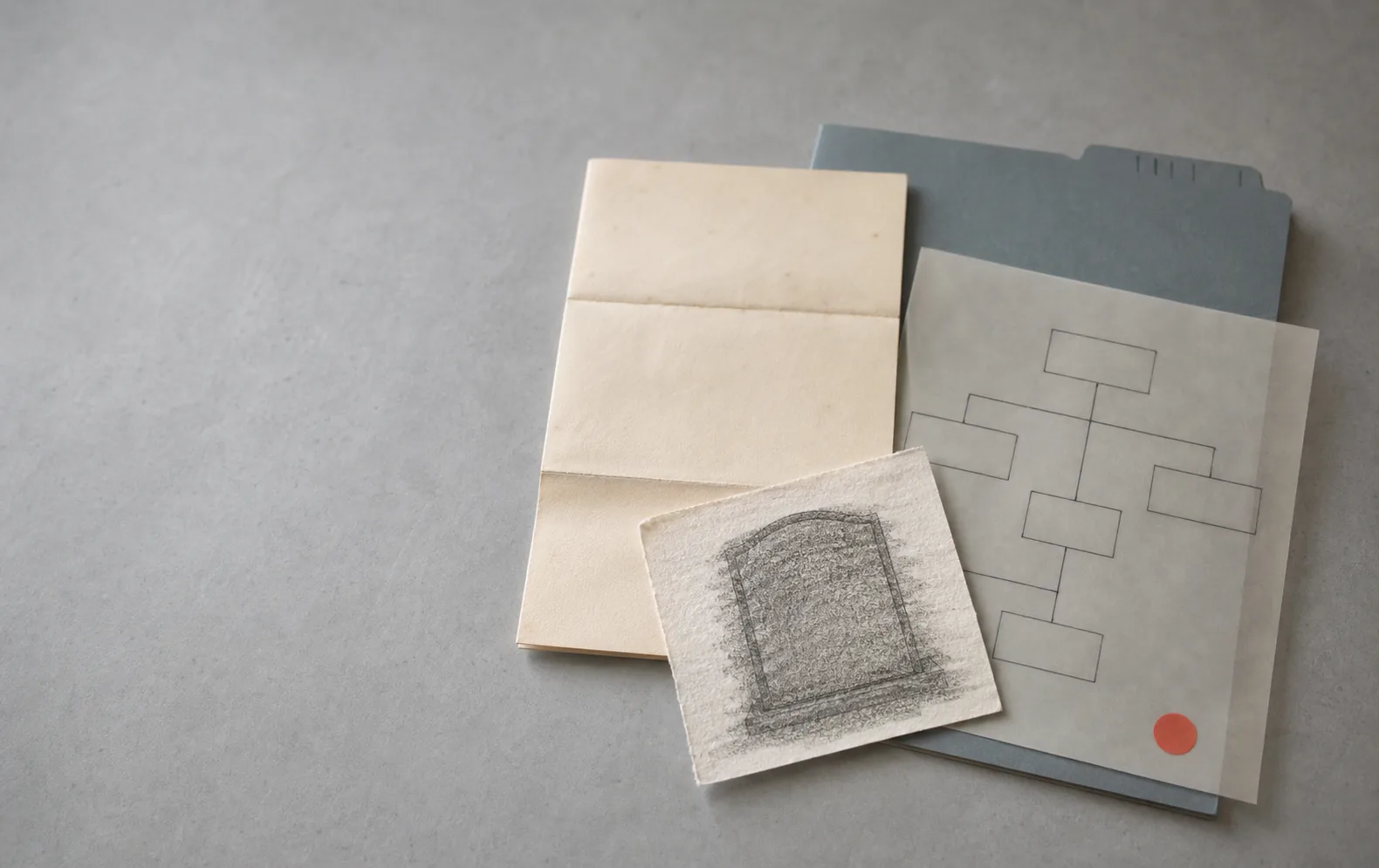Folded service letter, memorial rubbing, vellum workflow diagram, and muted folder tab on a gray archival table.