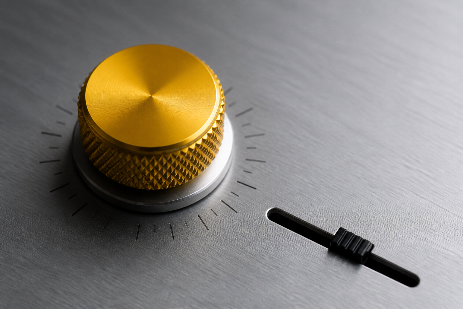 Macro photograph of a machined aluminum knob with a signal-yellow knurled cap beside a small black fader on a brushed metal faceplate.