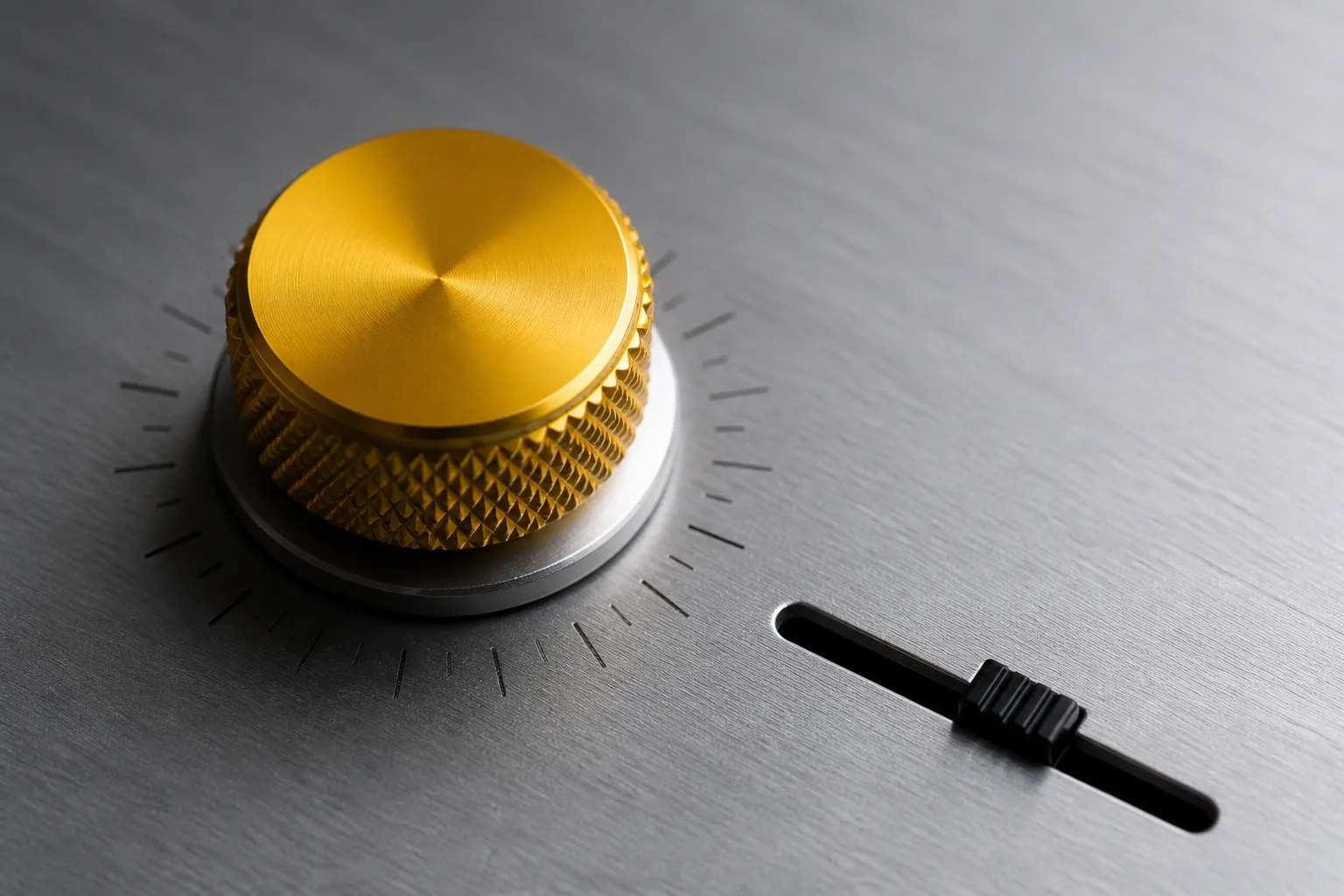 Macro photograph of a machined aluminum knob with a signal-yellow knurled cap beside a small black fader on a brushed metal faceplate.